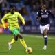 Jonathan Rowe dribbles past a defender in a Norwich City match, showcasing his agility and skill.