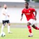 Mandela Keita in action during a football match, demonstrating his skills as a midfielder.
